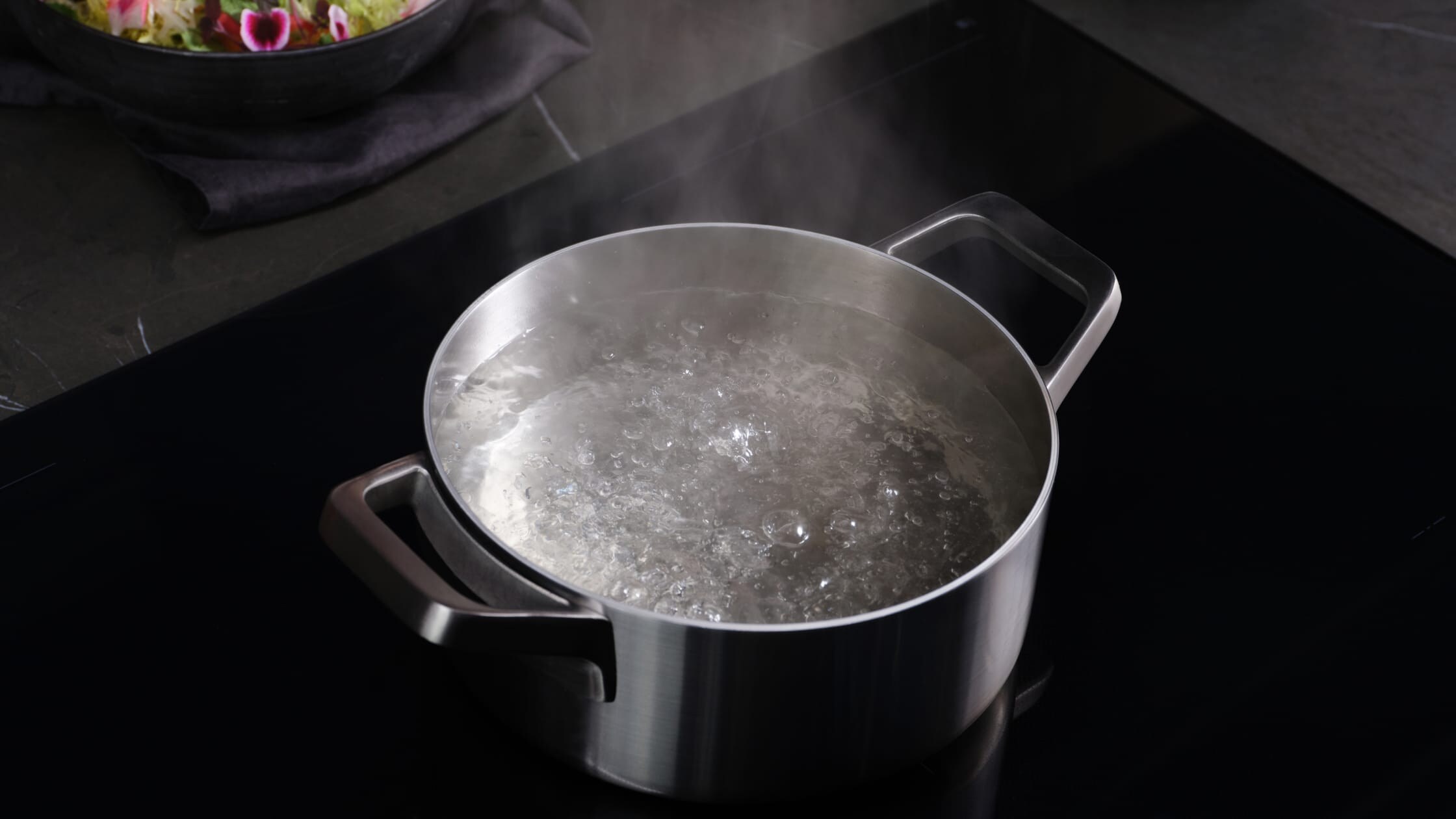Kattila kiehuvaa vettä induktiotasolla