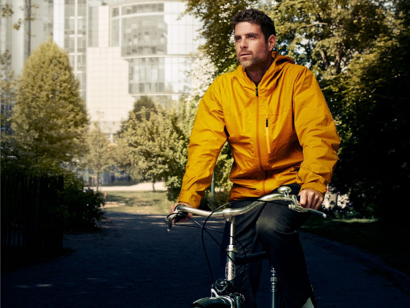 Man som cyklar med gul jacka