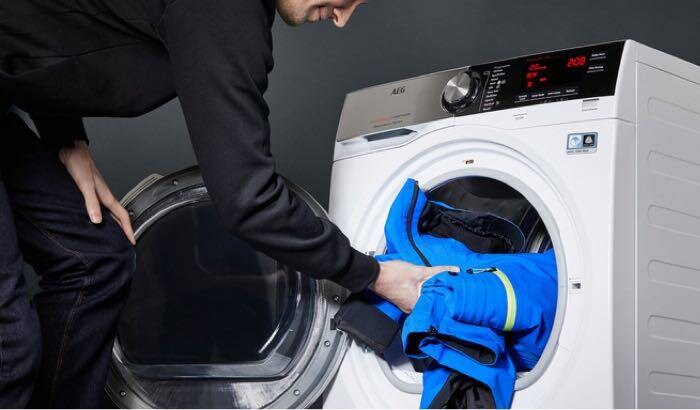 mies täyttää kuivausrumpua