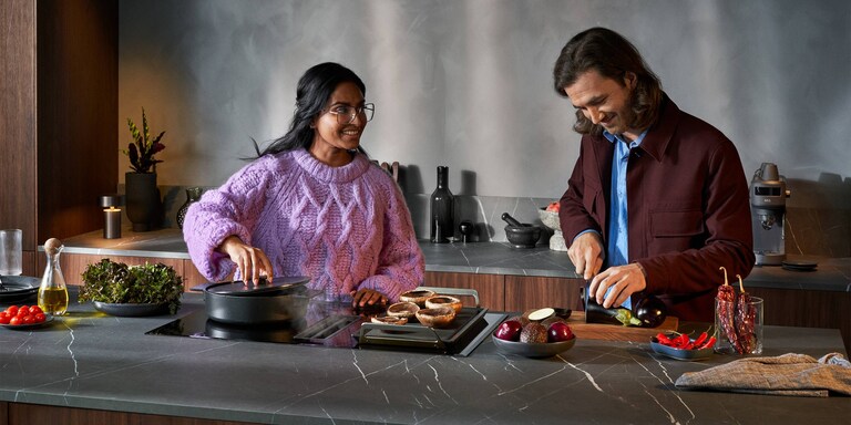 Mies ja nainen kokkaamassa keittiössä