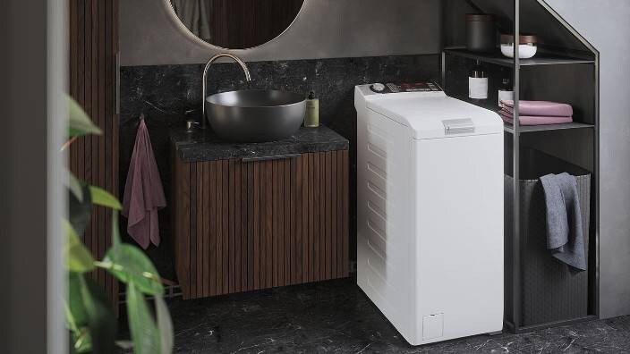 Päältä täytettävä pesukone pienessä kylpyhuoneessa. 