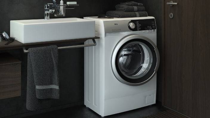 Kompakti pyykinpesukone pienessä kylpyhuoneessa. 